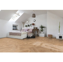 Dormitor luminos cu fereastră de mansardă, pat și parchet cu model herringbone