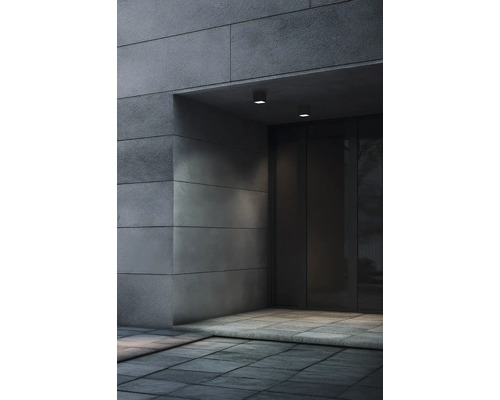 Exteriorul unei intrări de clădire cu placare de piatră și iluminat