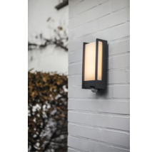 Lumină de perete exterior cu senzor de mișcare pe un zid de cărămidă