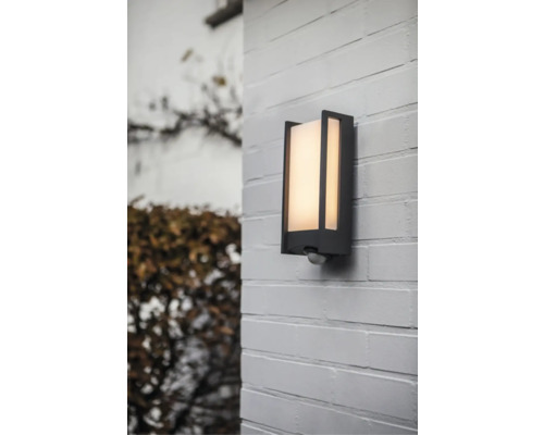 Lumină de perete exterior cu senzor de mișcare pe un zid de cărămidă