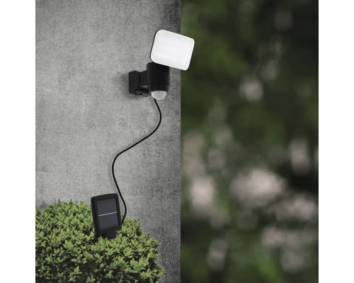 Lampa solară cu senzor de mișcare pentru montare pe perete deasupra unei plante