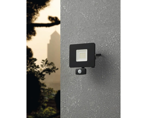 Reflector LED negru de exterior cu senzor de mișcare pe un perete