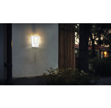 Lumină de perete exterioară aprinsă pe un perete de casă