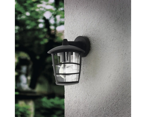 Lumină de perete exterioară neagră cu sticlă transparentă montată pe un perete