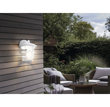 Ambianță de grădină cu aplică de perete exterioară iluminată și zonă de relaxare