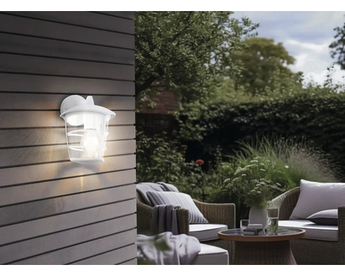 Ambianță de grădină cu aplică de perete exterioară iluminată și zonă de relaxare