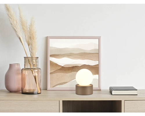 Scenă decorativă cu lampă de masă, imagine și vaze pe o masă