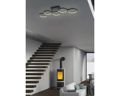 Interior modern cu plafonieră hexagonală, scară din lemn și sobă de teracotă