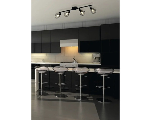 Bucătărie modernă cu chicinetă neagră, scaune de bar transparente și o lampă de tavan neagră cu patru spoturi.