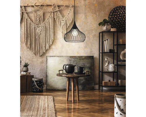 Cameră de zi cu macrame pe perete, abajur din sârmă, măsuță cu ceainic și raft