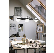 Atelier modern cu lampă suspendată deasupra unui birou cu materiale de artă.