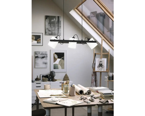 Atelier modern cu lampă suspendată deasupra unui birou cu materiale de artă.