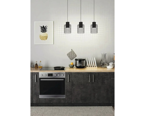 Scenă de bucătărie cu trei lămpi suspendate deasupra unui blat cu aparate și un cadru cu o imagine cu ananas