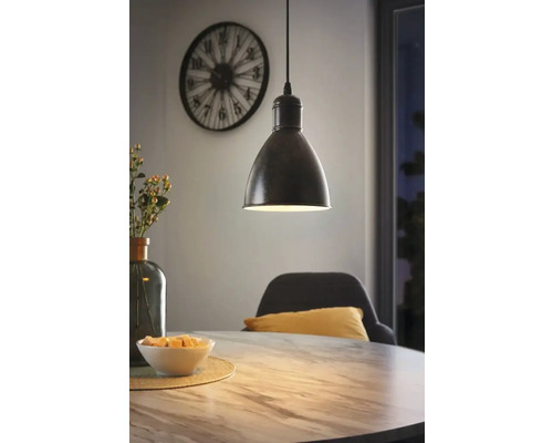 Lampa suspendată deasupra unei mese de sufragerie într-o sală de mese cu un ceas pe perete