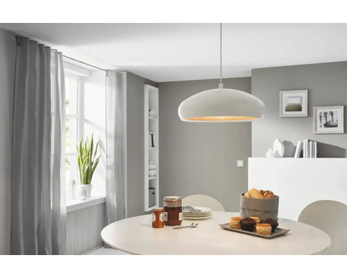 Sufragerie cu masă, lampă suspendată și fereastră cu perdele.