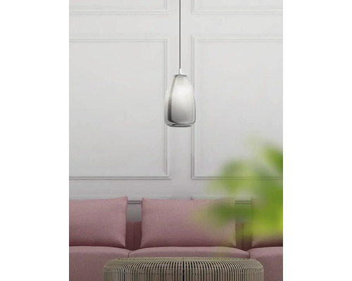 Lampa suspendată metalică deasupra canapelei și a mesei