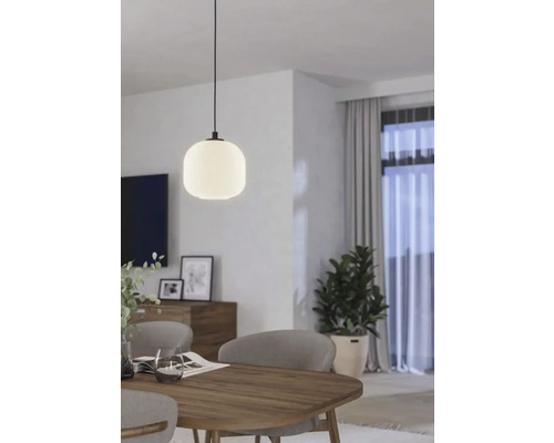 Lampa suspendată deasupra unei mese din lemn într-o cameră luminoasă