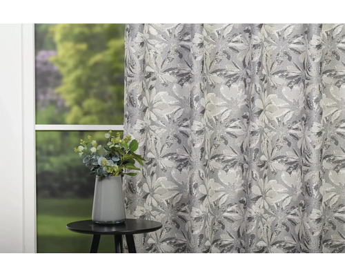 Perdea decorativă cu model floral lângă o masă cu o vază