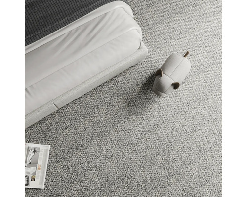 Prim-plan cu un covor cu un pat, o revistă și un decor