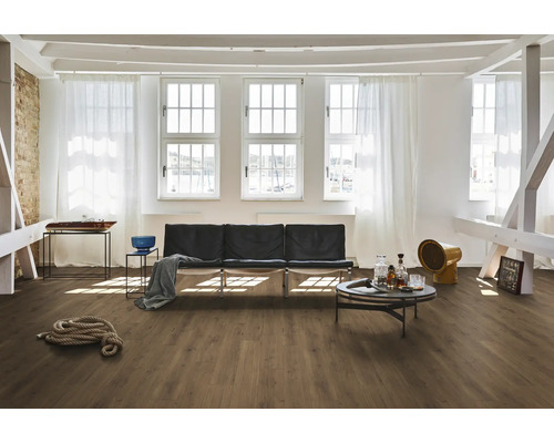 Cameră luminoasă cu podea din lemn, canapea, masă și ferestre