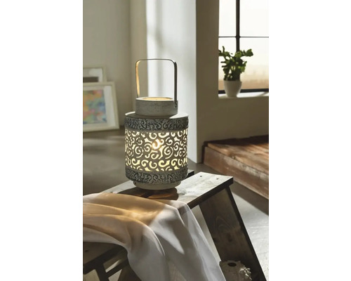 Lanternă decorativă cu model filigranat pe o masă