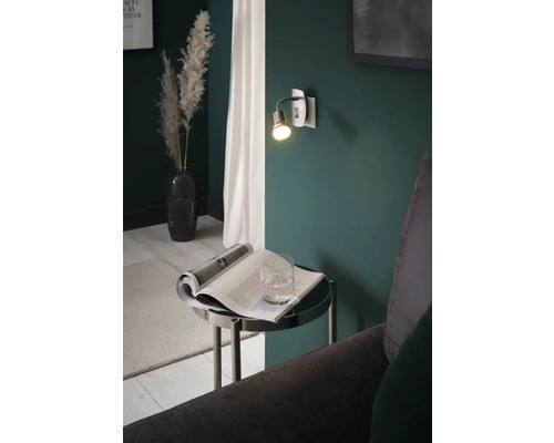Cameră de zi cu lampă de perete, măsuță laterală și decorațiuni pentru o atmosferă confortabilă