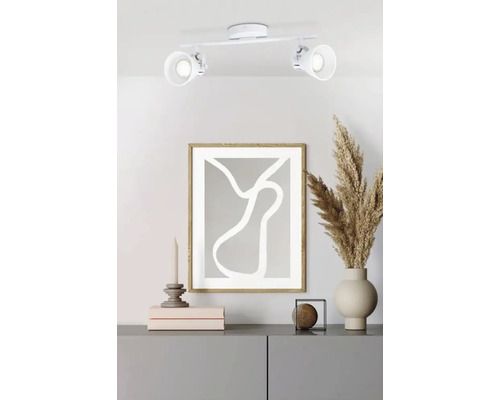 Cameră de zi cu plafonieră, tablou și decorațiuni pe comodă