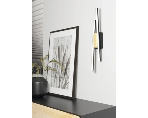 Lampa modernă de perete din metal lângă imaginea înrămată