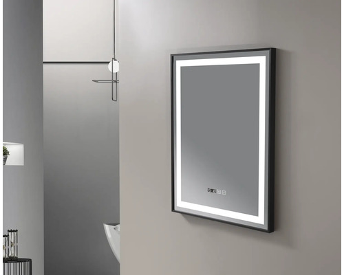 Oglindă iluminată cu ramă neagră într-un cadru de baie.