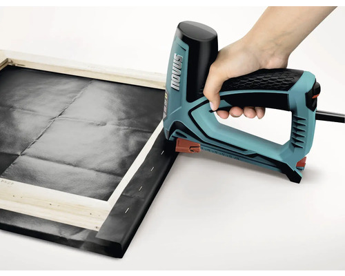 O persoană folosește un capsator electric pentru a întinde pânza pe un cadru de lemn. Logo Novus.