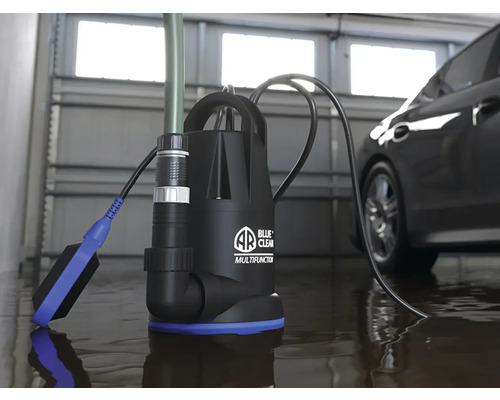 Pompă multifuncțională în uz într-un garaj lângă o mașină, pentru îndepărtarea apei.