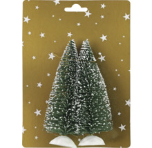 Doi pomi de Crăciun în miniatură cu zăpadă pe o carte