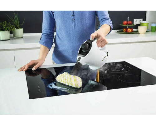 O persoană curăță o plită cu un curățător cu abur Kärcher și o lavetă de curățare.