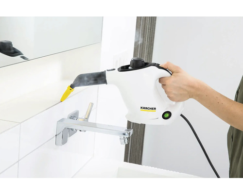 Persoană curățând rosturile de gresie cu un curățător cu abur Kärcher în baie.