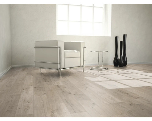 Cameră luminoasă cu podea laminată, fotoliu, masă și vaze decorative.