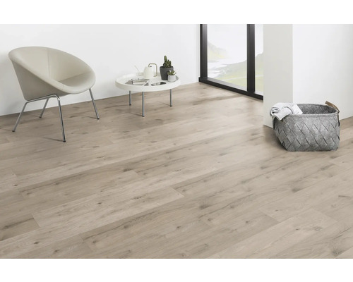 Cameră de zi luminoasă cu podea laminată, scaun și coș