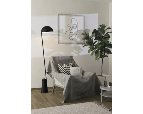 Scenă de interior cu fotoliu, pătură, perne, lampadar, plantă de interior și tablou
