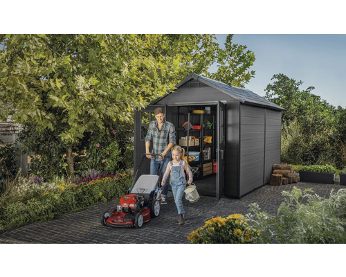 Scenă cu căsuță de grădină, mașină de tuns iarba, bărbat și copil la grădinărit