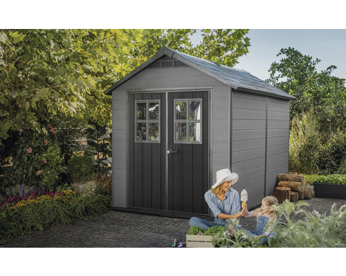 Scenă de grădină cu magazie de scule, mamă și copil