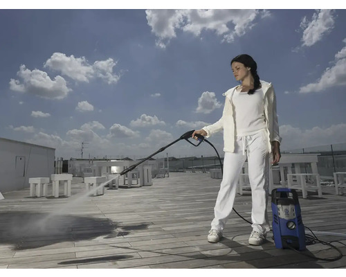 Femeie curăță terasa cu un curățător cu presiune