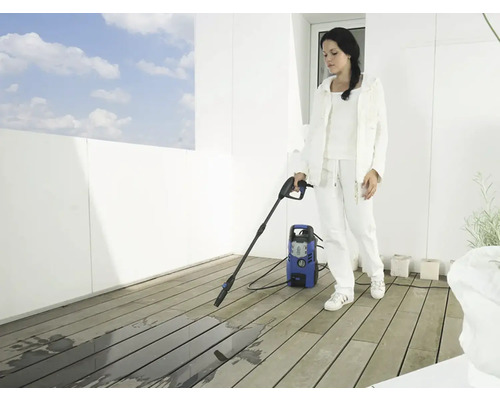 Femeie curăță terasa cu un aparat de curățat cu presiune