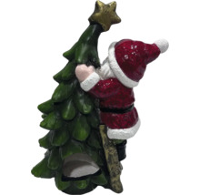 Figurină decorativă a lui Moș Crăciun care se urcă într-un pom de Crăciun