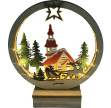 Decorațiune de Crăciun iluminată cu Moș Crăciun într-o sanie în fața unui decor cu case