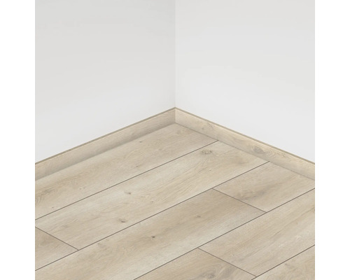 Vedere din colț a unei camere cu podea laminată și plinte