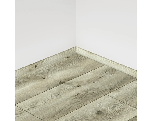 Pardoseală laminată montată cu plintă asortată pe un perete al camerei