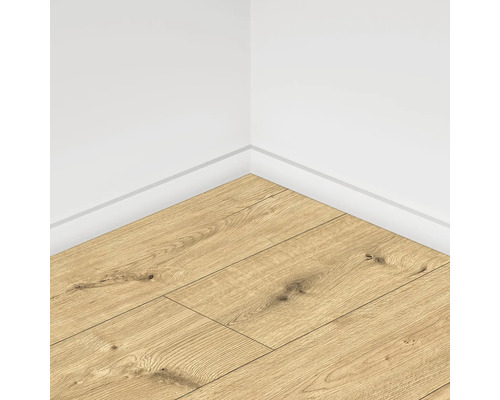 Colț de cameră cu podea laminată cu aspect de lemn și plintă albă