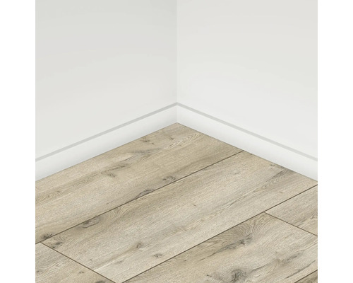 Colț de cameră cu podea laminată deschisă la culoare și plinte albe