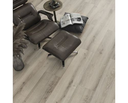 Podea laminată deschisă la culoare în camera de zi cu fotoliu și măsuță laterală