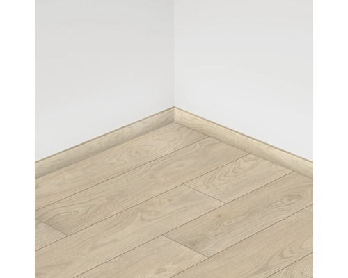 Vedere din colț a unei camere cu podea laminată și plinte montate