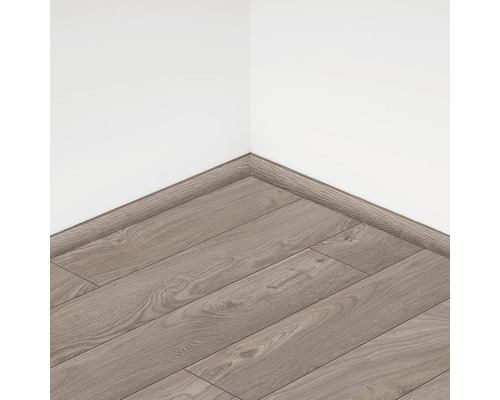 Podea laminată montată cu plintă asortată pe un perete al camerei